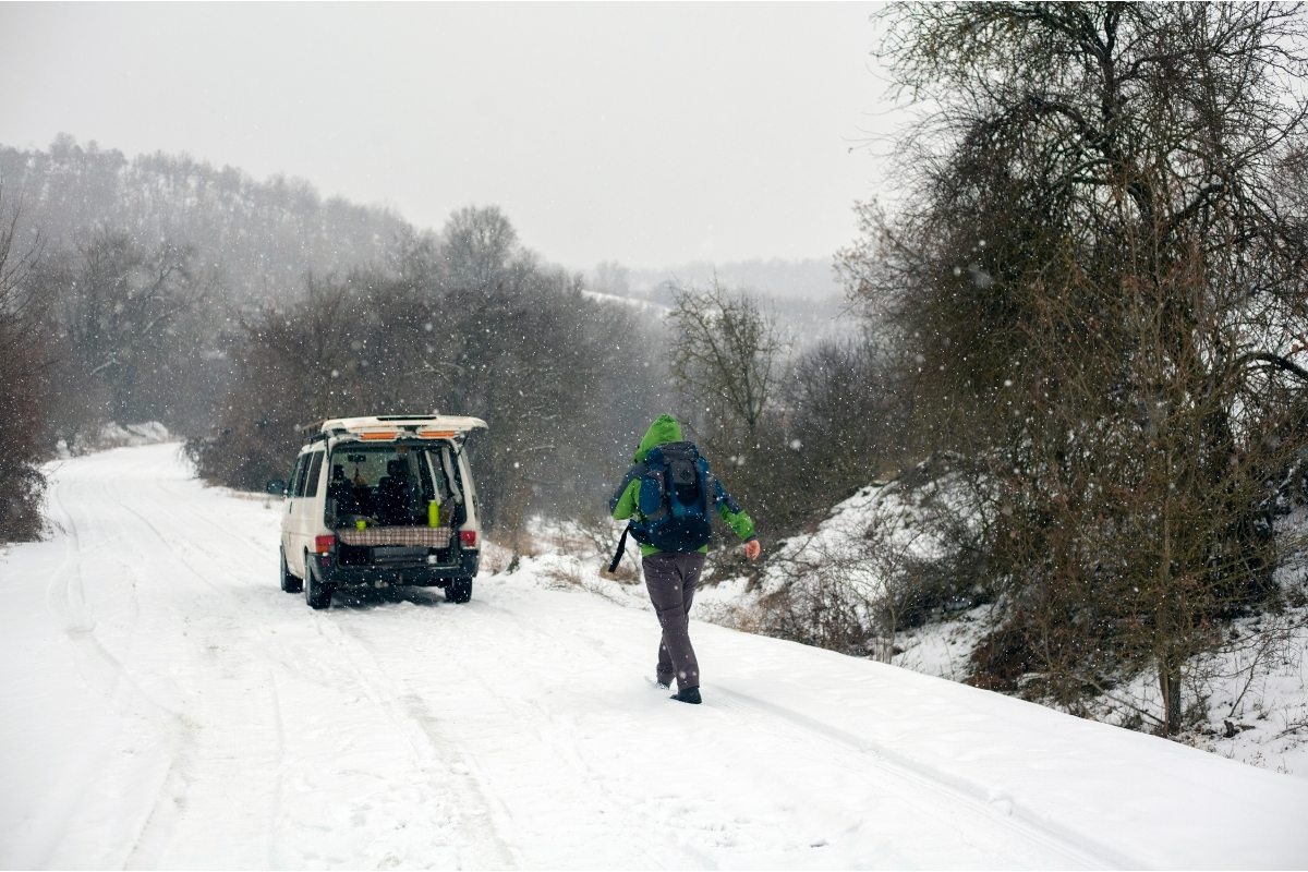 Homme revenant à pied à un van dans la neige